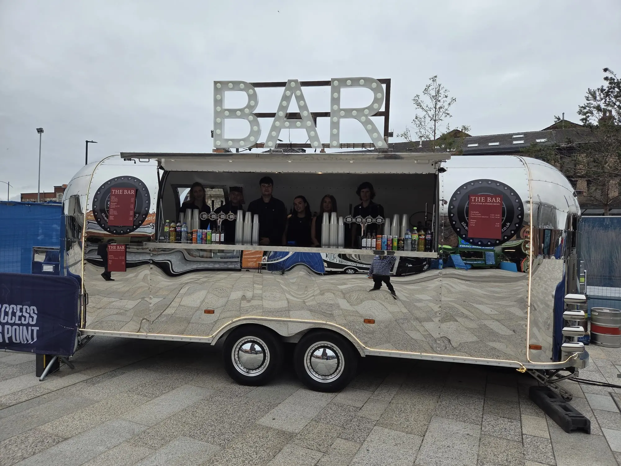 Polished Airstream event bar staffed and ready for service