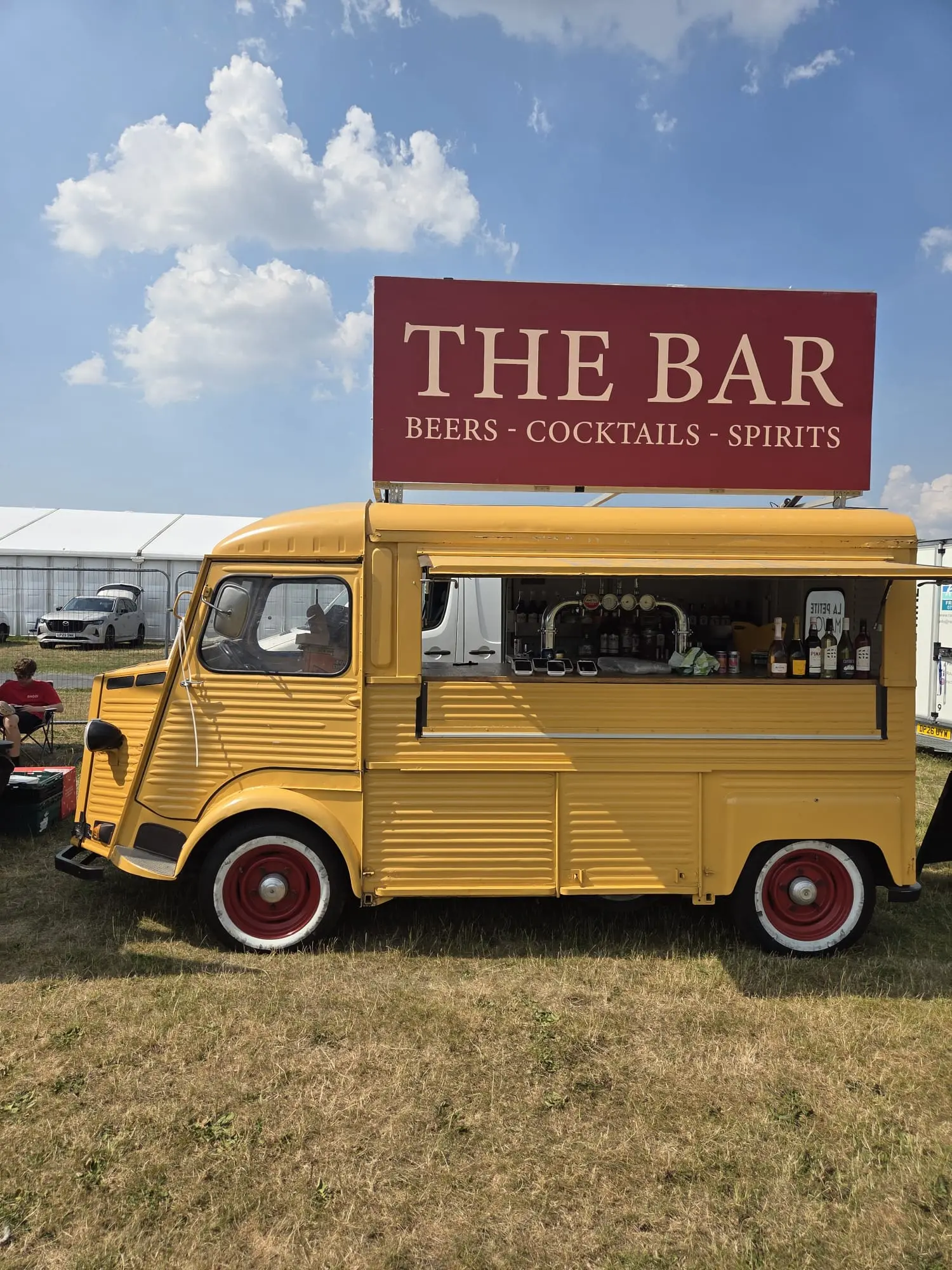 Yellow vintage mobile bar in an outdoor festival field
